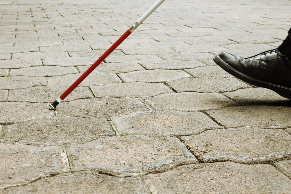 man's foot walking with white cane