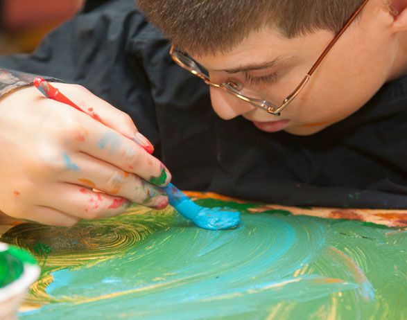 Visually impaired man is painting.