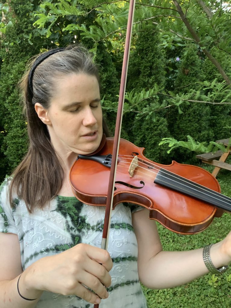 Susanna is standing outside and playing her fiddle