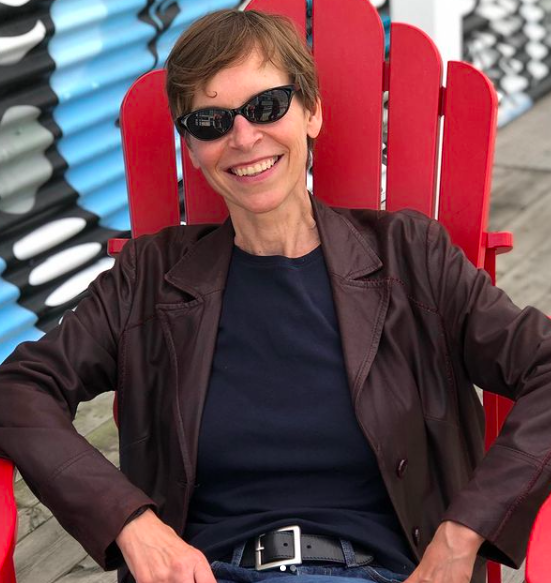 Alex Bulmer sitting on a red Muskoka chair